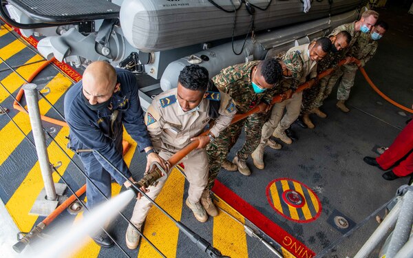 211206-N-PH222-2024 SAVU SEA (Dec. 6, 2021) Chief Damage Controlman Raul Avila, from Inglewood, California, left, conducts damage control training with members of the Timor-Leste Defense Force from the mission bay aboard Independence-variant littoral combat ship USS Charleston (LCS 18), during Cooperation Afloat Readiness and Training (CARAT) exercise. In its 27th year, the CARAT series is comprised of multinational exercises, designed to enhance U.S. and partnered navies’ abilities to operate together in response to traditional and non-traditional maritime security challenges in the Indo-Pacific region. Charleston, part of Destroyer Squadron (DESRON) 7, is on a rotational deployment in the U.S. 7th Fleet area of operation to enhance interoperability with partners and serve as a ready-response force in support of a free and open Indo-Pacific region. (U.S. Navy photo by Mass Communication Specialist 2nd Class Ryan M. Breeden)