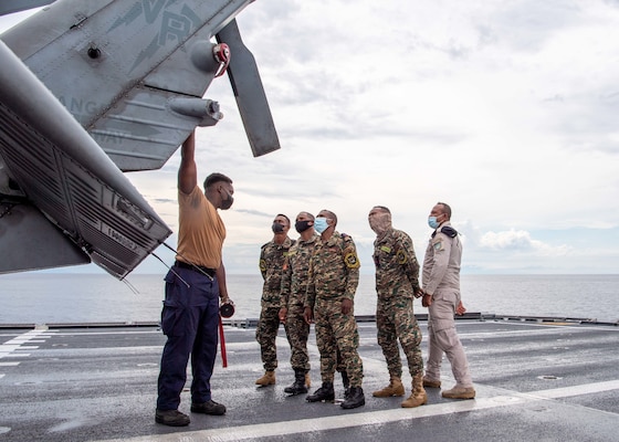 211206-N-PH222-2474 SAVU SEA (Dec. 6, 2021) Aviation Electronic's Technician 2nd Class Labaron Johnson, from Conroe, Texas, assigned to the “Blackjacks” of Helicopter Sea Combat Squadron (HSC) 21, gives a tour to members of the Timor-Leste Defense Force of an MH-60S Sea Hawk from the flight deck aboard Independence-variant littoral combat ship USS Charleston (LCS 18), during Cooperation Afloat Readiness and Training (CARAT) exercise. In its 27th year, the CARAT series is comprised of multinational exercises, designed to enhance U.S. and partnered navies’ abilities to operate together in response to traditional and non-traditional maritime security challenges in the Indo-Pacific region. Charleston, part of Destroyer Squadron (DESRON) 7, is on a rotational deployment in the U.S. 7th Fleet area of operation to enhance interoperability with partners and serve as a ready-response force in support of a free and open Indo-Pacific region. (U.S. Navy photo by Mass Communication Specialist 2nd Class Ryan M. Breeden)