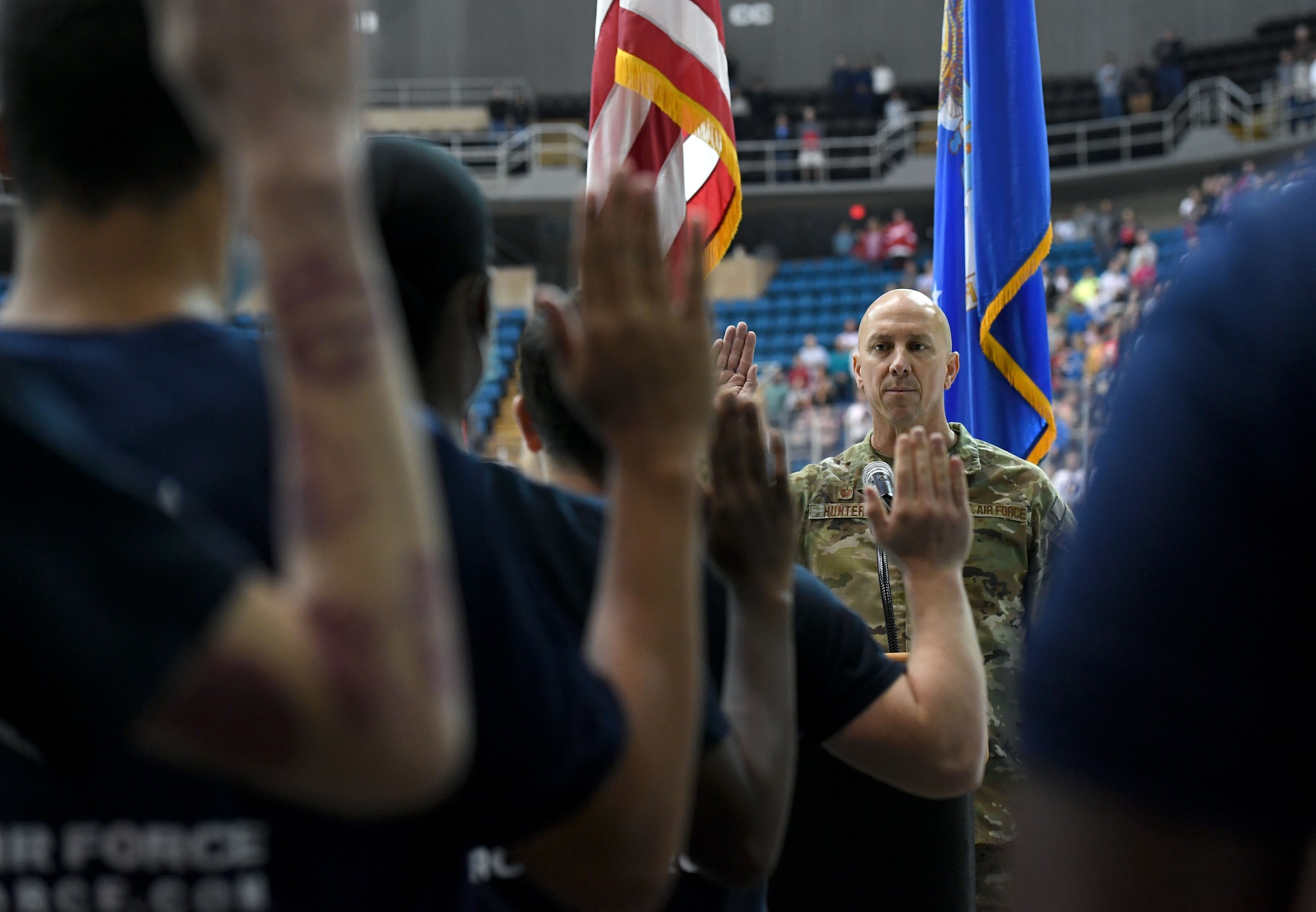 U.S. Air Force Col. William Hunter, 81st Training Wing commander, recites the oath of office to 16 Air Force delayed entry program recruits during the Biloxi Pro Hockey game inside the Mississippi Coast Coliseum at Biloxi, Mississippi, Dec. 2, 2021. The Keesler Air Force Base Honor Guard and Second Air Force leadership also participated in pre-game festivities. (U.S. Air Force photo by Kemberly Groue)