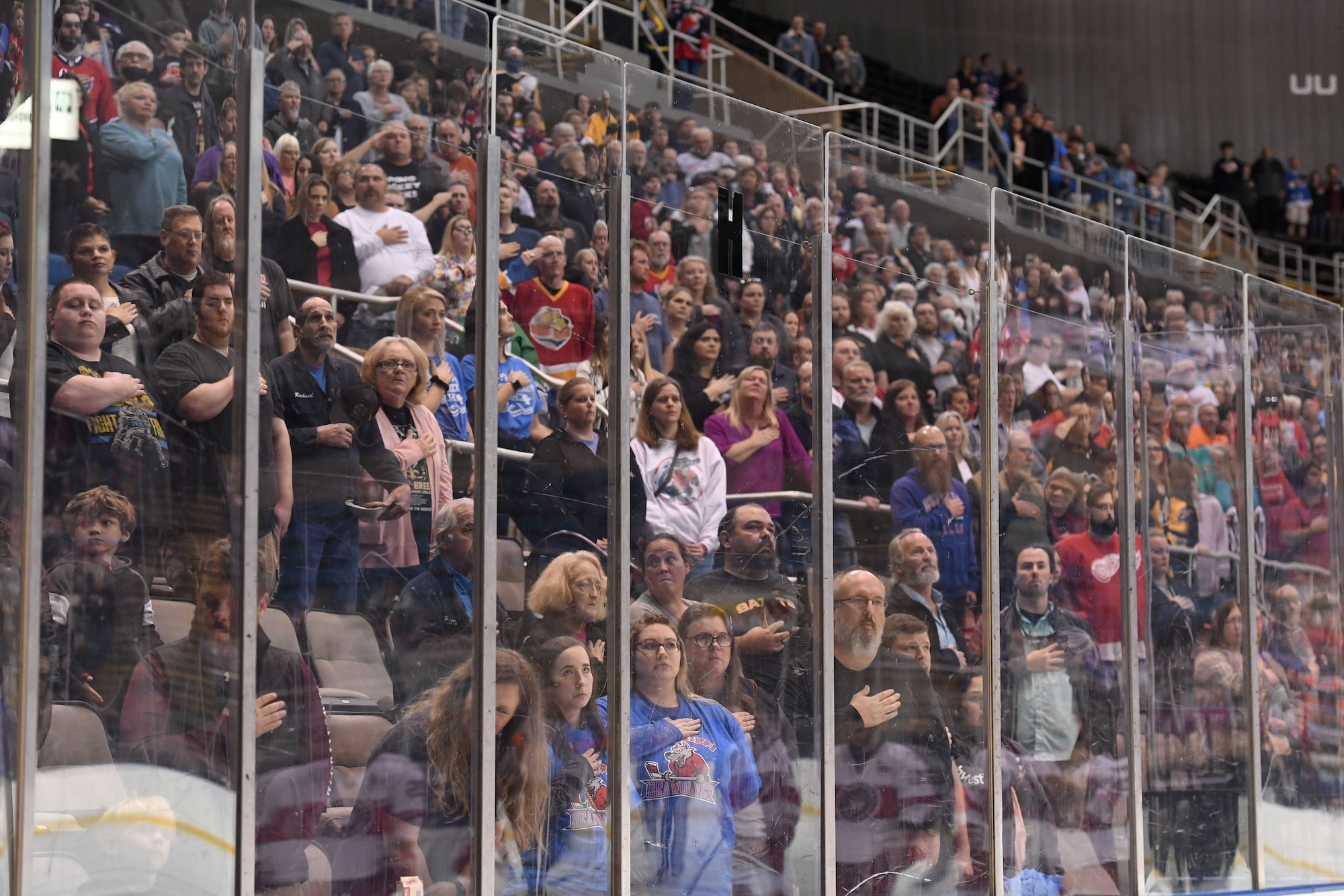 Keesler Air Force Base personnel and community personnel place their hands over their heart during the singing of the national anthem during the Biloxi Pro Hockey game inside the Mississippi Coast Coliseum at Biloxi, Mississippi, Dec. 2, 2021. The Keesler Honor Guard and leadership from Second Air Force and the 81st Training Wing participated in pre-game festivities. (U.S. Air Force photo by Kemberly Groue)