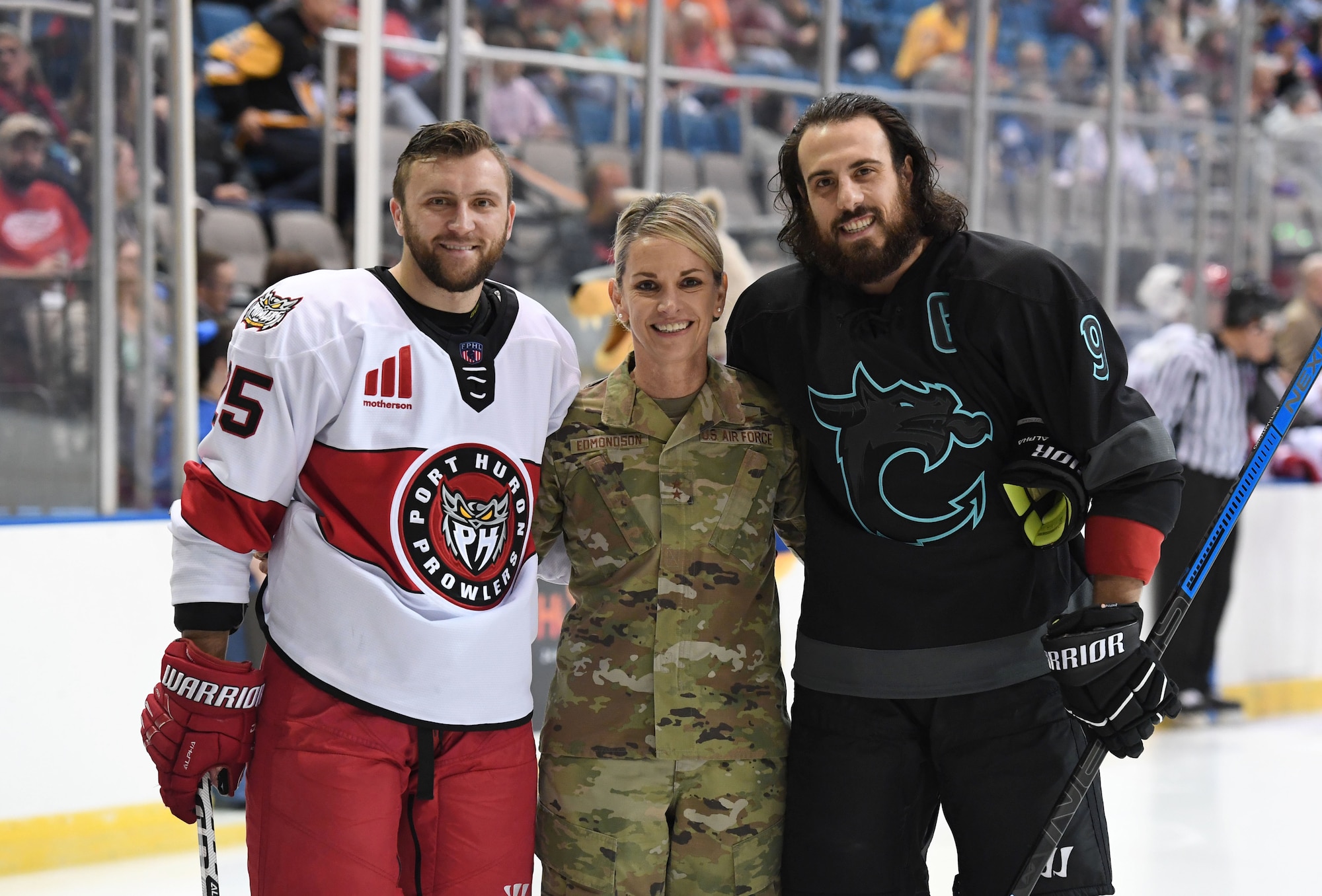 U.S. Air Force Maj. Gen. Michele Edmondson, Second Air Force commander, poses for a photo with the team captains following the ceremonial puck drop during the Biloxi Pro Hockey game inside the Mississippi Coast Coliseum at Biloxi, Mississippi, Dec. 2, 2021. The Keesler Air Force Base Honor Guard and 81st Training Wing leadership also participated in pre-game festivities. (U.S. Air Force photo by Kemberly Groue)