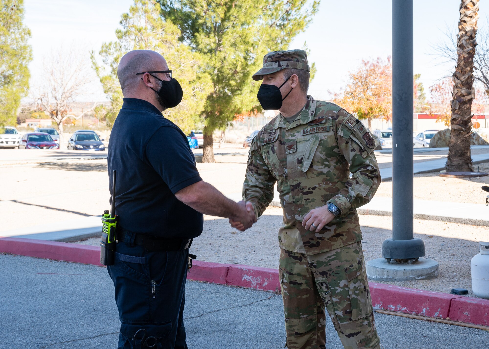 Col. Glenn Rineheart, Air Force Operational Test and Evaluation Center, Detachment 5 Commander, presents a coin to paramedic Tim Reynolds at Edwards Air Force Base, California, Dec. 1. Reynolds and fellow medical personnel were the first responders to a medical emergency involving an AFOTEC Det. 5 team member. Rineheart credits base emergency personnel for possibly saving the individual's life. (Air Force photo by Giancarlo Casem)