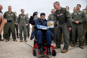 Retired Brig. Gen. Charles McGee, a documented Tuskegee Airman, holds up a bottle of cola to honor the tradition of shooting down an enemy aircraft during his tour of the 99th Flying Training Squadron Dec. 6, 2021, at Joint Base San Antonio, Texas. In celebration of the U.S. Air Force’s 75th anniversary, McGee was treated to a heritage tour of the 99th FTS and participated in a training mission in a T-1A Jayhawk aircraft simulator the day before his 102nd birthday.