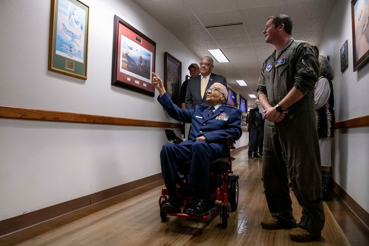 Retired Brig. Gen. Charles McGee, documented Tuskegee Airman, comments on a Red Tail painting during a tour of the 99th Flying Training Squadron with Maj. Nicholas Fairbrother, 99th FTS instructor pilot, Dec. 6, 2021, at Joint Base San Antonio, Texas. In celebration of the U.S. Air Force’s 75th anniversary, McGee was treated to a heritage tour of the 99th FTS and participated in a training mission in a T-1A Jayhawk aircraft simulator.