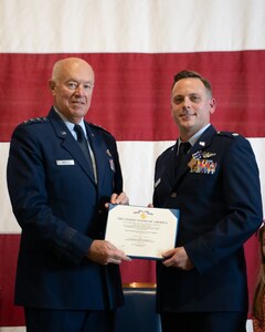 Retired Lt. Gen. Harry Wyatt III, former Director of the Air National Guard, presents Lt. Col. Michael Coloney, 125th Fighter Squadron director of operations, with the Distinguished Flying Cross during a ceremony at the Tulsa Air National Guard Base, Okla., Dec. 5, 2021. Coloney was awarded the Distinguished Flying Cross for his heroism during a mission over Afghanistan in 2018. (Oklahoma Air National Guard Photo by Tech. Sgt. Rebecca Imwalle)