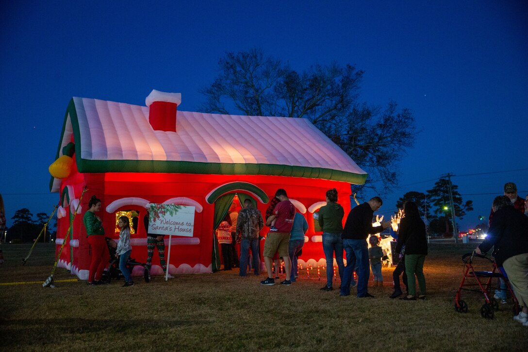 Service members and families line up to get their picture taken with Santa Claus during the annual tree lighting ceremony at Marine Corps Air Station Cherry Point, North Carolina, Dec. 3, 2021.
