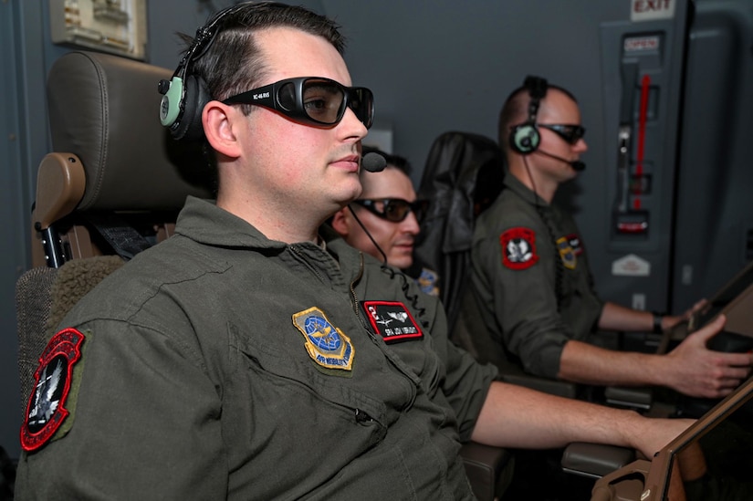 Senior Airman Jon Vermont and Staff Sgt. Jared Evans, 2nd Air Refueling Squadron boom operator instructors, train Tech. Sgt. Joseph Deltoro, 2nd ARS boom operator, on the system operations during an air-refueling mission on a KC-46 Pegasus while over the North Atlantic Ocean, Dec. 2, 2021. The KC-46 is designed to refuel allied and coalition aircraft and provide multifunctional support, like passenger and cargo transport along with medical and humanitarian relief. (U.S. Air Force photo by Senior Airman Ariel Owings)