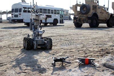A robot operated by the Explosive Ordnance Disposal team approaches two downed Unmanned Aerial Systems, armed with a simulated explosive device, during an exercise at Al Dhafra Air Base, United Arab Emirates, Dec. 3, 2021. The 380th Expeditionary Security Forces Squadron at the base has responsibility for countering potential UAS threats. (U.S. Air Force photo by Master Sgt. Dan Heaton)