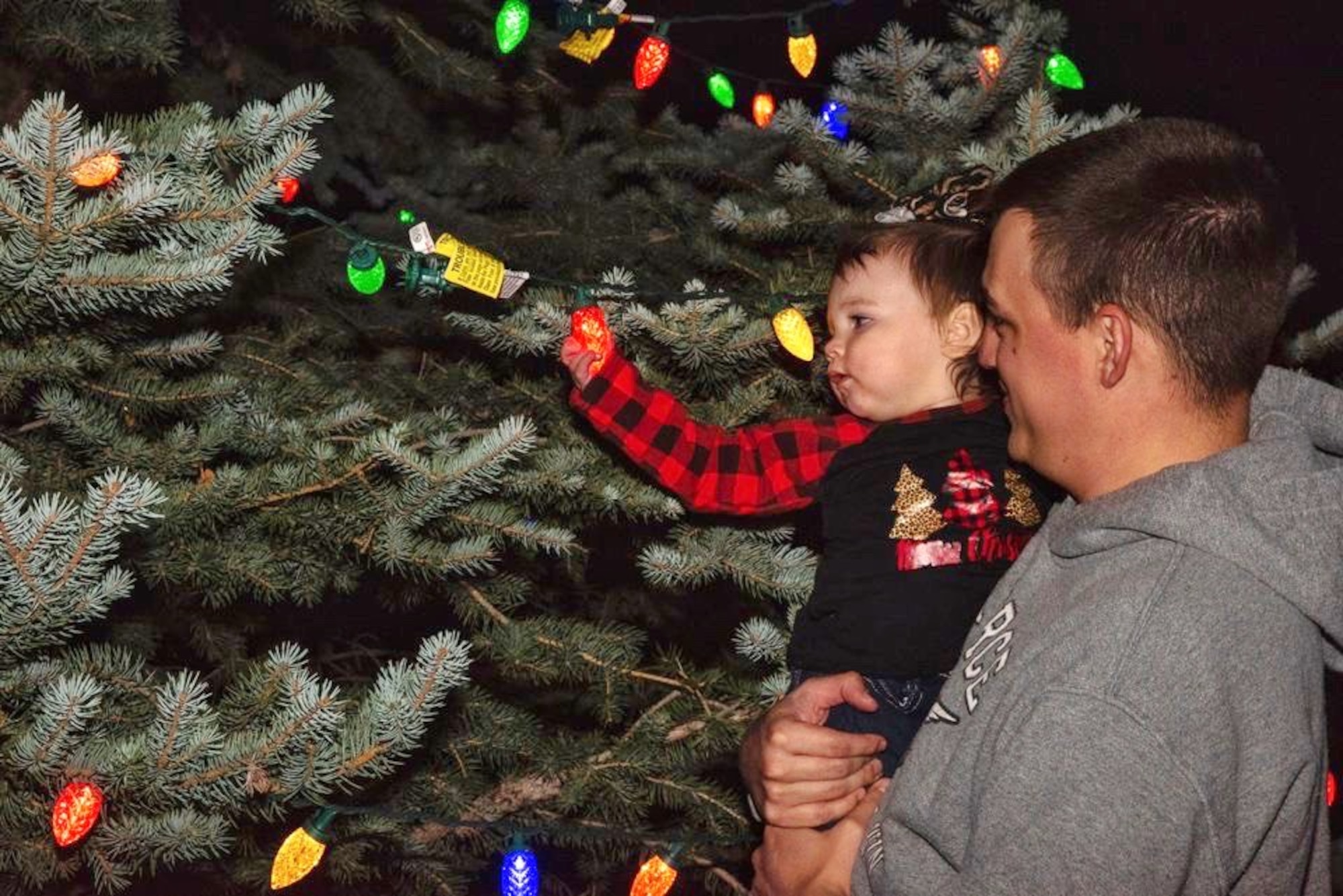 family next to Christmas tree