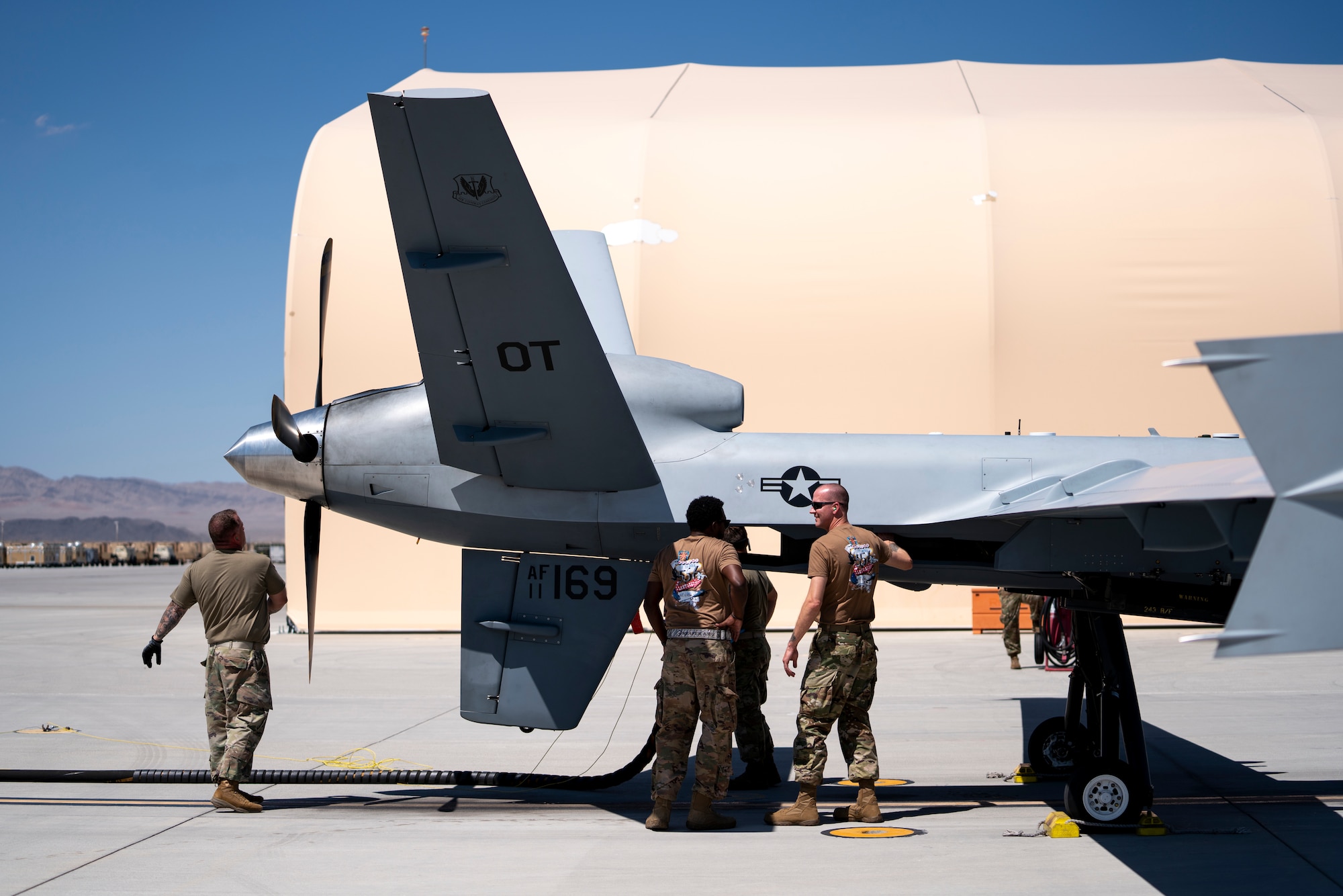 U.S. Air Force maintenance Airmen from the 556thTest and Evaluation Squadron perform a warm refuel test, where the aircraft is grounded and refueled while powered on but with the engine not running, at Creech Air Force Base, Nevada, Sept. 2, 2021. The warm refuel test was conducted to test if the operation can be accomplished in austere locations.  (U.S. Air Force photo by Tech. Sgt. Emerson Nuñez)