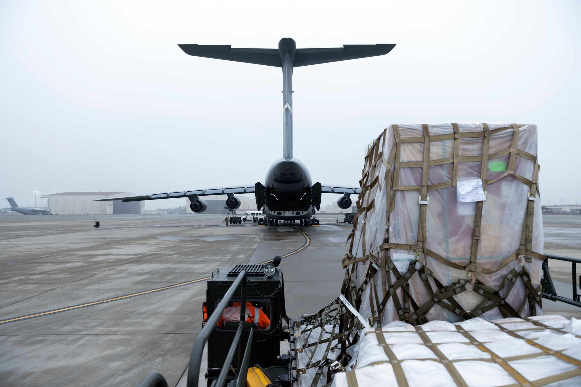 Photos of Airmen palletizing and loading water bottles and supplies into a C-5 for Hawaii