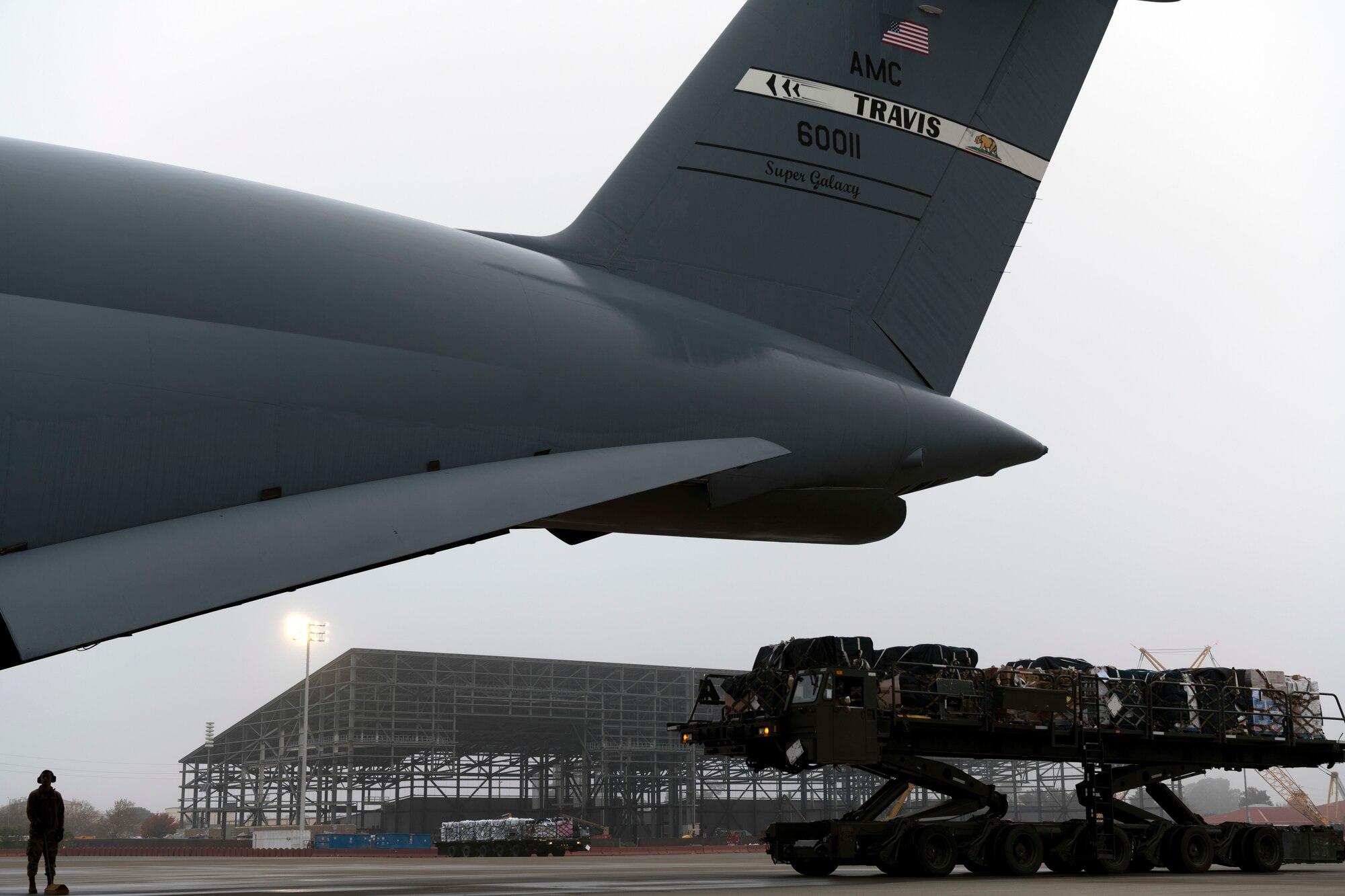 Photos of Airmen palletizing and loading water bottles and supplies into a C-5 for Hawaii