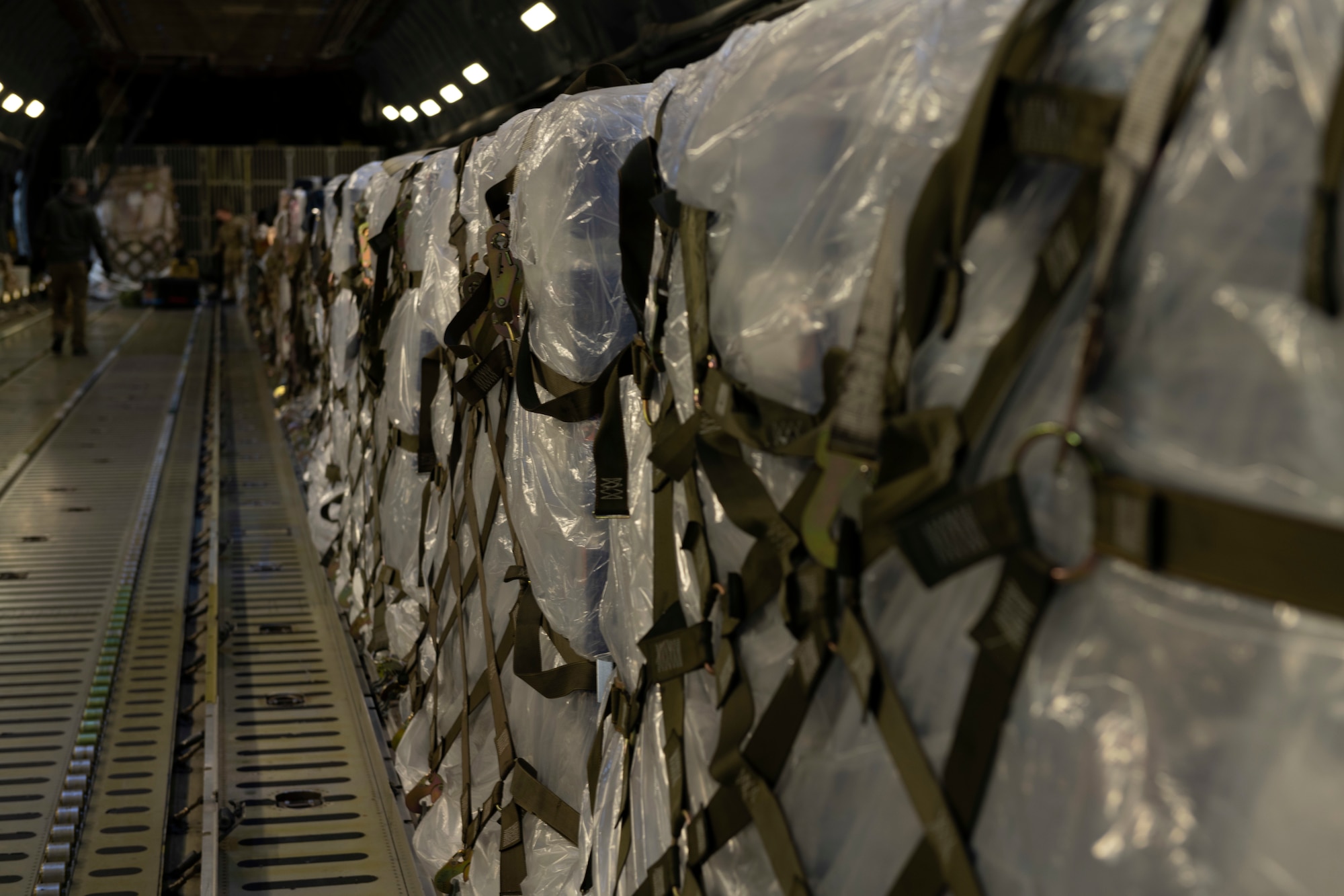 Photos of Airmen palletizing and loading water bottles and supplies into a C-5 for Hawaii