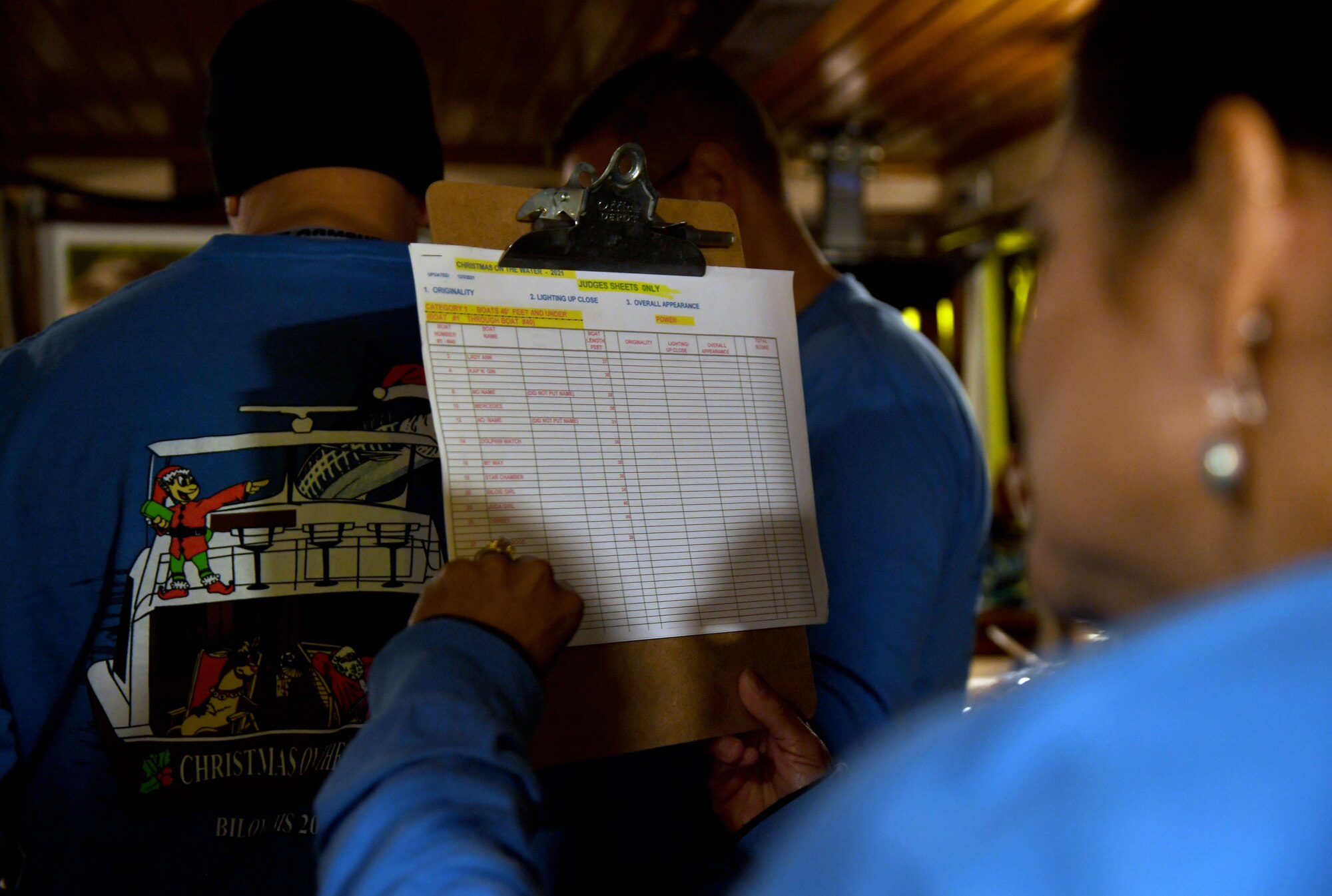 Rachel Kafer, wife of U.S. Air Force Col. James Kafer, 81st Training Wing vice commander, reviews a judge's scoring sheet during the 36th Annual Christmas on the Water Boat Parade in Biloxi, Mississippi, Dec. 4, 2021. Keesler Air Force Base leadership judged more than 25 boats during the annual holiday event. (U.S. Air Force photo by Kemberly Groue)