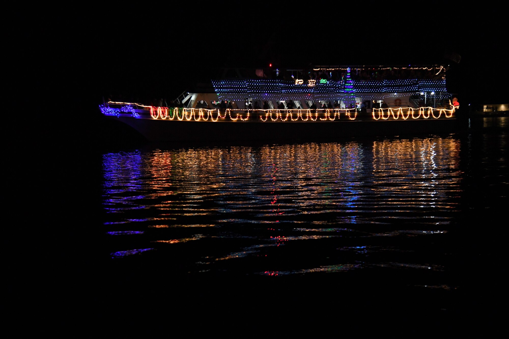 A decorated boat passes the judging boat during the 36th Annual Christmas on the Water Boat Parade in Biloxi, Mississippi, Dec. 4, 2021. Keesler Air Force Base leadership judged more than 25 boats during the annual holiday event. (U.S. Air Force photo by Kemberly Groue)