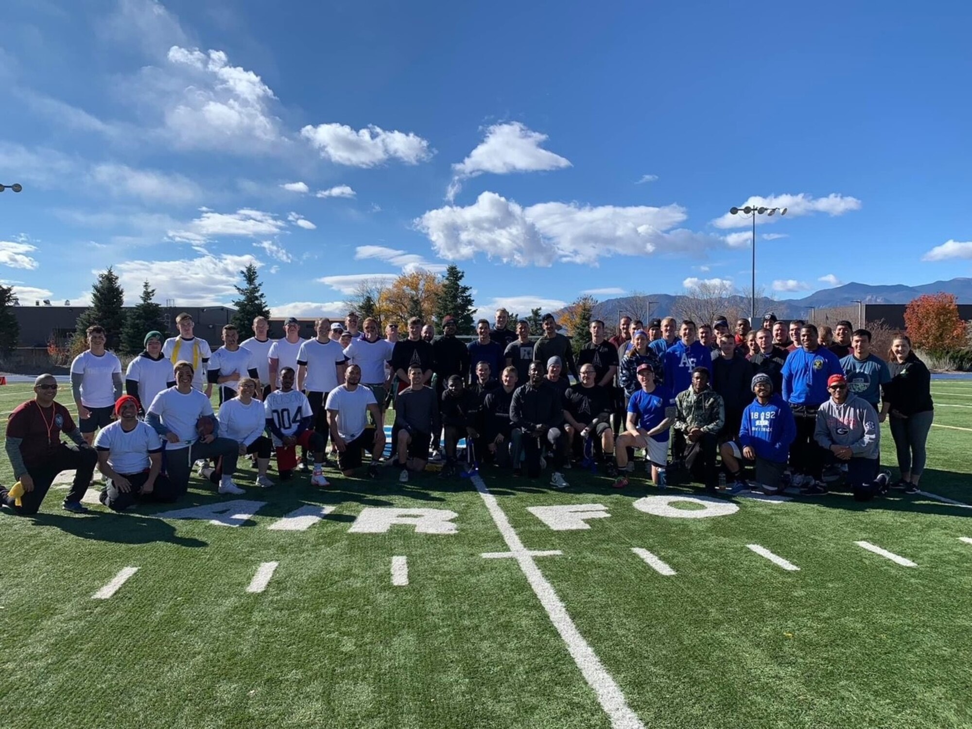 Football team members stand together in a group photo