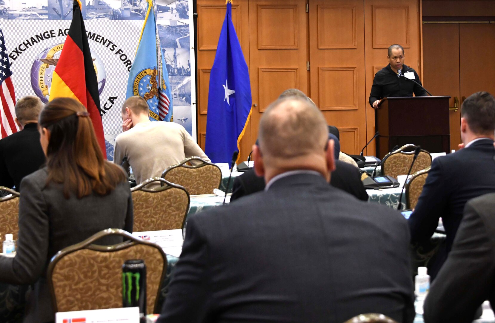 a man speaks from a podium in front of an audience