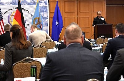 a man speaks from a podium in front of an audience