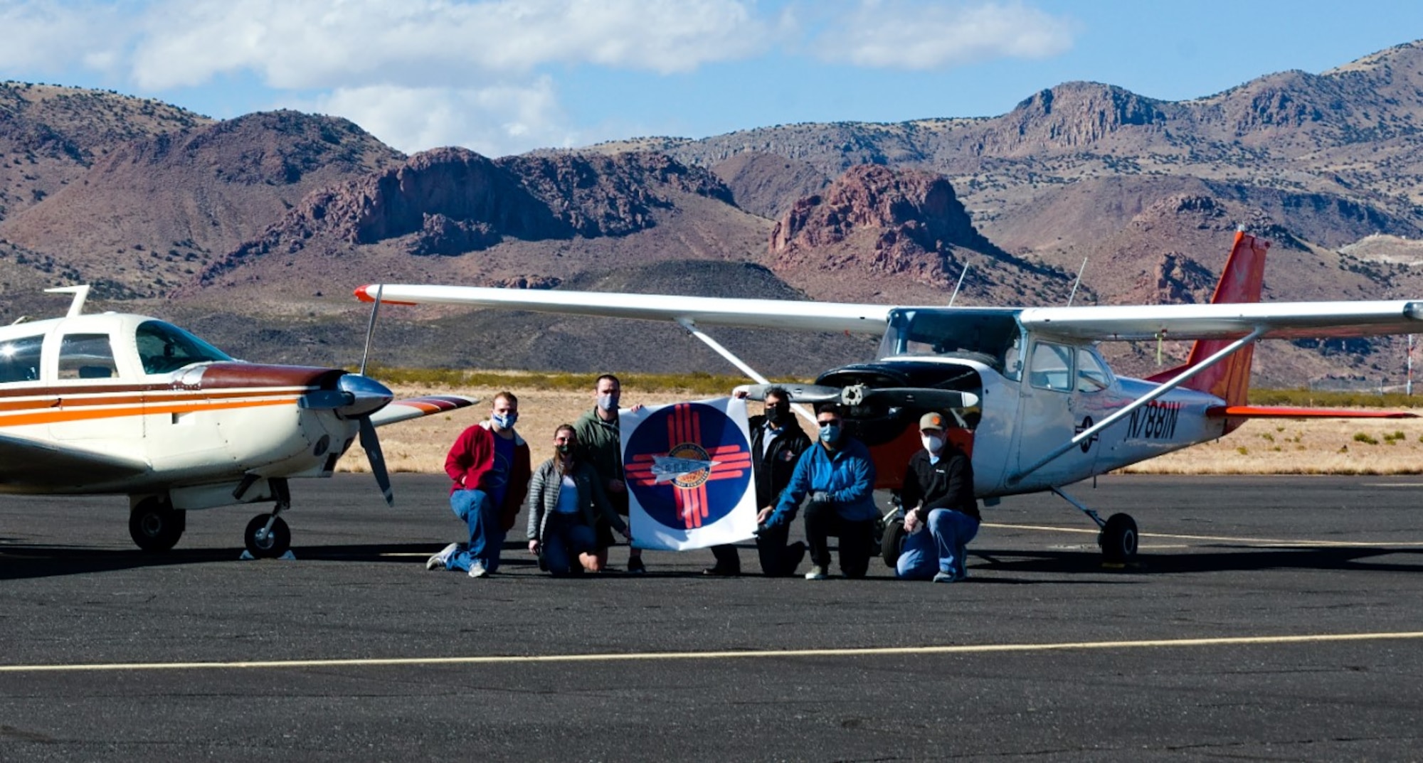 Group photo of Society of Flight Test Engineers New Mexico Chapter officers in front of two small aircraft