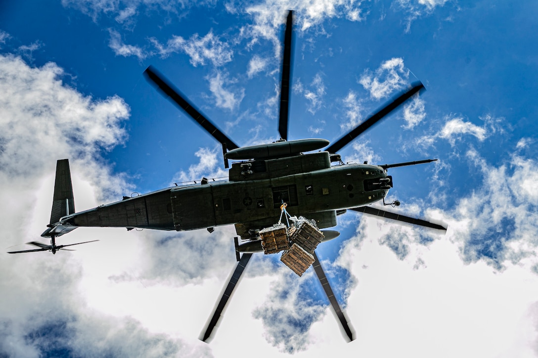 A U.S. Marine Corps CH-53E Super Stallion to delivers cargo attached by Marines with Landing Support Platoon, 3rd Landing Support Battalion, Combat Logistics Regiment 3, 3rd Marine Logistics Group, during a helicopter support team operation on Camp Gonsalves, Okinawa, Japan, Dec. 3, 2021. Marines with 3rd LSB and Marine Medium Tiltrotor Squadron 265, 1st Marine Aircraft Wing, executed external lifts in support of 9th Engineer Support Battalion, 3rd MLG, to supply and transport materials for reconstructing cinderblock structures previously destroyed in a typhoon. 3rd MLG, based out of Okinawa, Japan, is a forward deployed combat unit that serves as III MEF’s comprehensive logistics and combat service support backbone for operations throughout the Indo-Pacific area of responsibility.