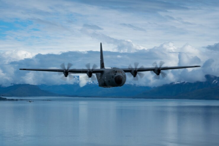 C-130J Super Hercules flying over water in Alaska.