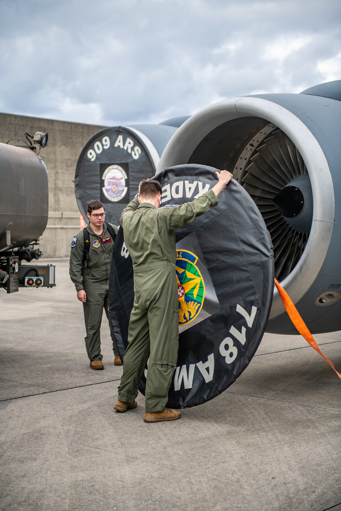 Two U.S. Air Force members remove the covers off the engines of a KC-135 Stratotanker