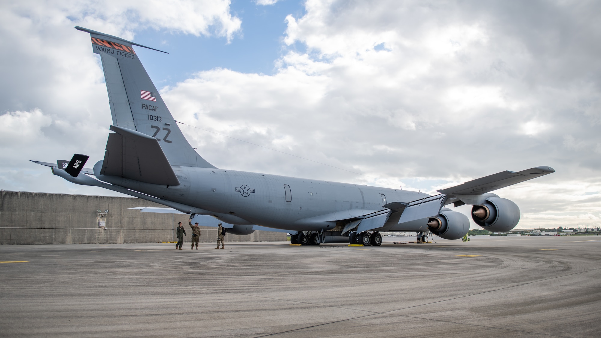 Three U.S. Air Force members inspect the underside of a KC-135 Stratotanker