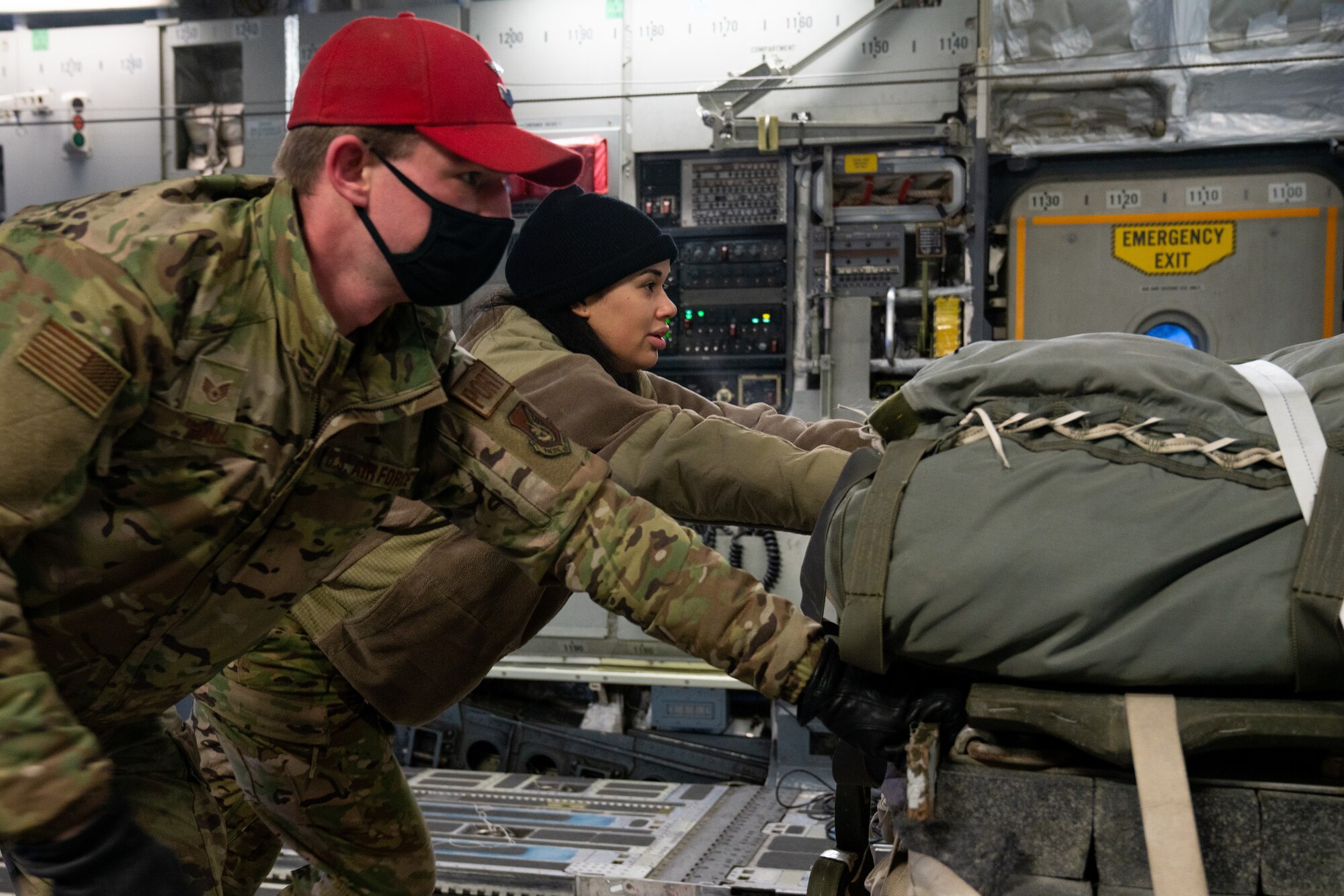 U.S. Air Force Staff Sgt. Marcus Hall, a 773d Logistics Readiness Squadron combat mobility supervisor, and Staff Sgt. Darian Johnson, a 3rd Operations Support Squadron loadmaster, push a cargo pallet onto a C-17 Globemaster III.