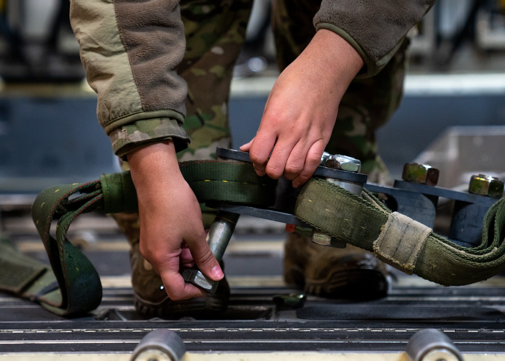 U.S. Air Force Staff Sgt Darian Johnson, a 3rd Operations Support Squadron loadmaster, secures a cargo pallet to a C-17 Globemaster III.