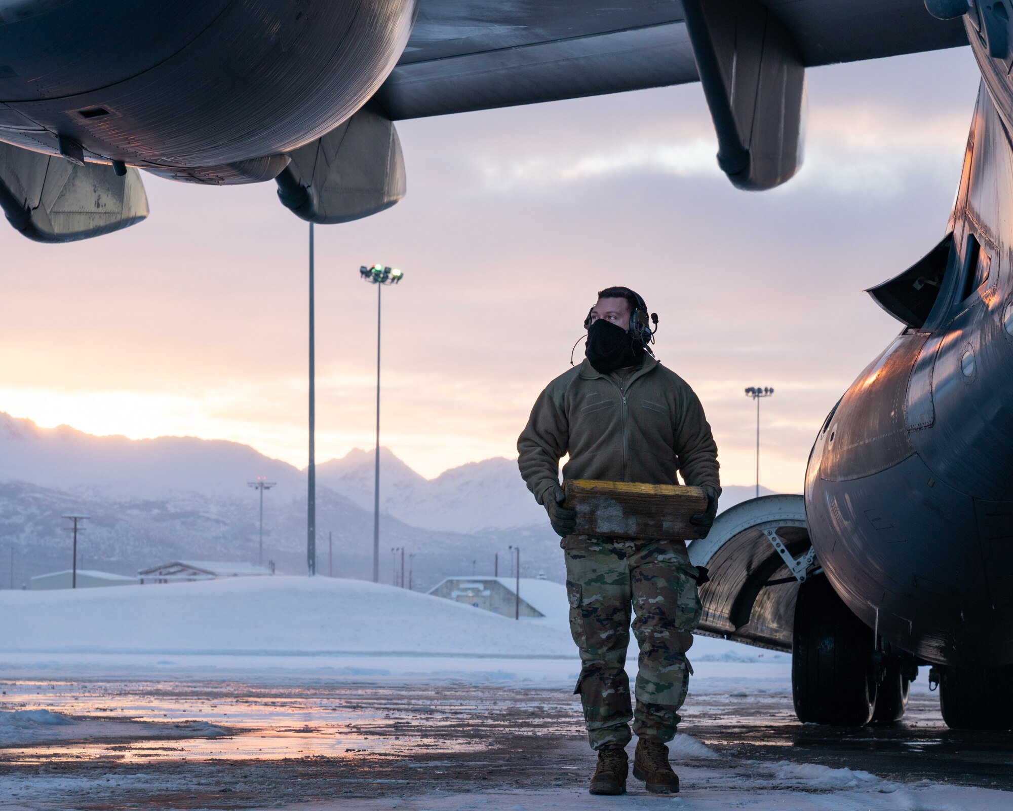 U.S. Air Force Staff Sgt. Chris Soto, a 703d Aircraft Maintenance Squadron crew chief, carries a tire chock.