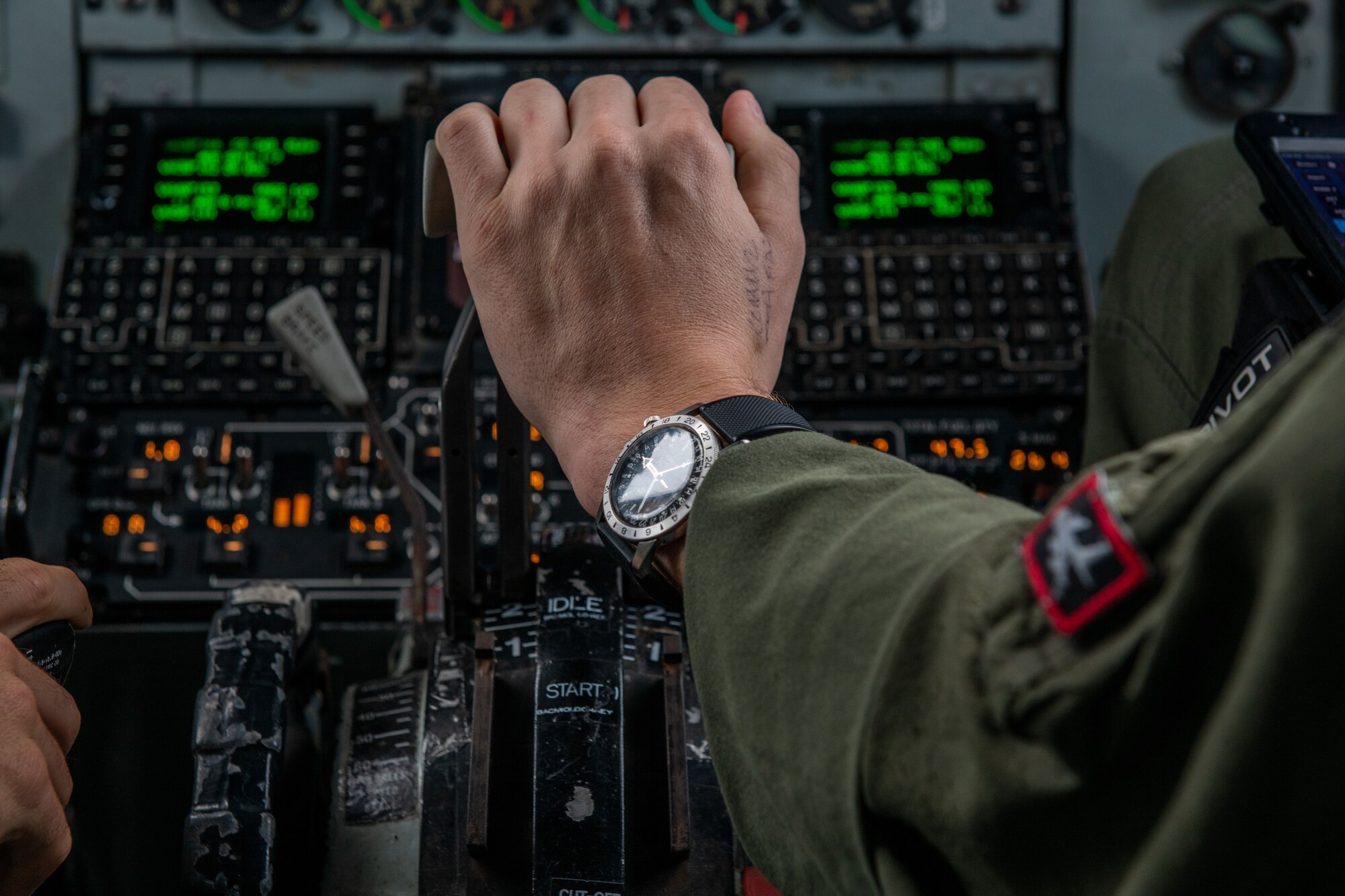 A pilot's watch catches the light from outside a plane