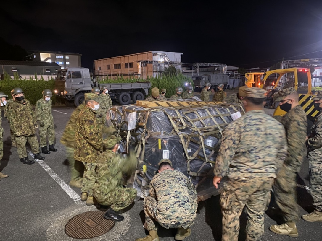 U.S. Marines assigned to or reinforcing 3rd Marine Expeditionary Brigade and members of the U.S. Army's 5th Security Force Assistance Brigade unload gear with Japan Ground Self Defense Force members of the Amphibious Ready Deployment Brigade in preparation for exercise Yama Sakura 81 aboard Camp Ainoura, Sasebo, Japan, Dec. 1, 2021. Yama Sakura is the largest U.S.-Japan bilateral and joint command post exercise which enables participants to work as dedicated partners in support of the Japan-U.S. security alliance and for continued peace and stability in the Indo-Pacific.