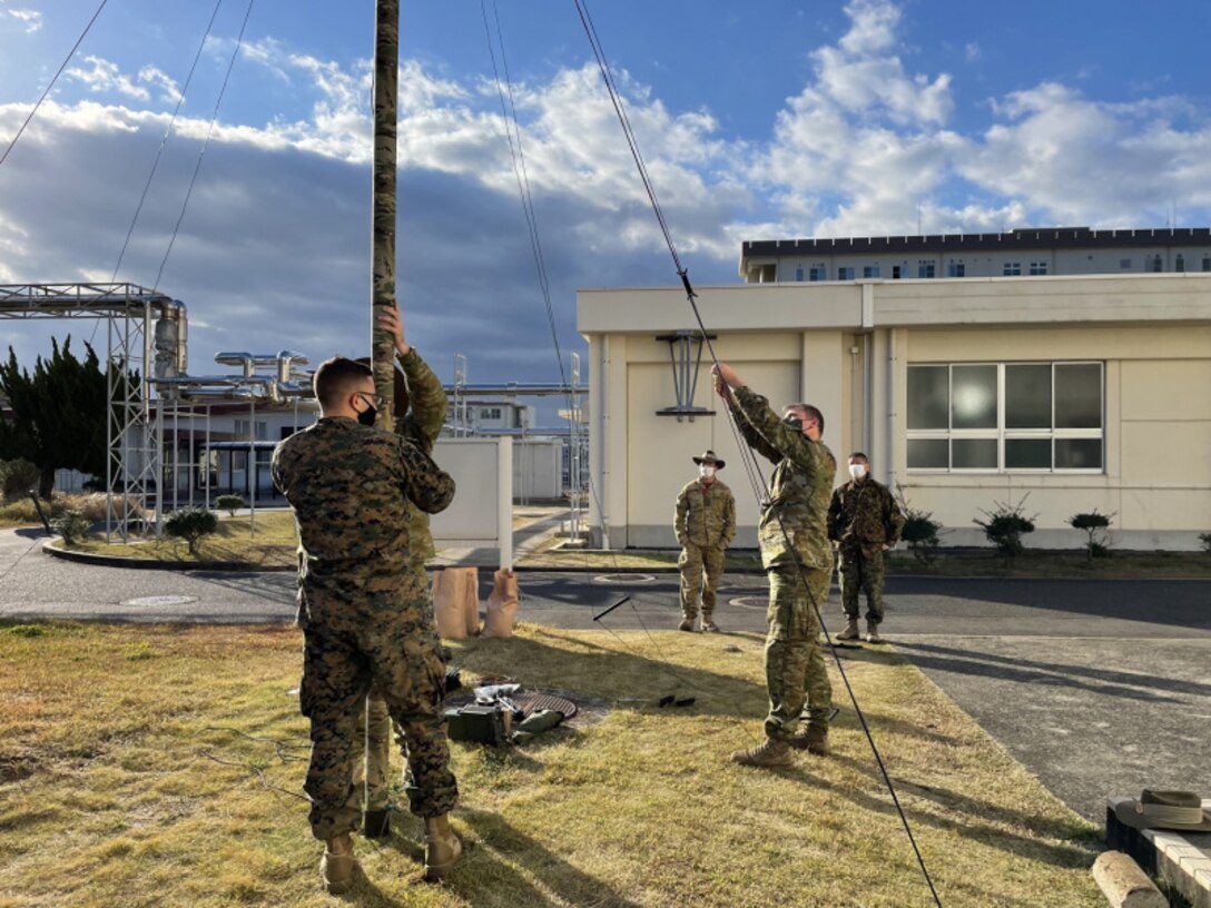 Australian Defence Force (ADF) Lt. James Christie, left, a signals observer from the ADF’s 1st Division, Japan Ground Self Defense Force Maj. Masaru Kanai, middle, communications chief for the Amphibious Rapid Deployment Brigade, and U.S. Marine Corps Cpl. Zachary Verrier, right, a radio operator from All-Domain Effects Team 1-1, 5th Air Naval Gunfire Liaison Company (ANGLICO), reinforcing 3rd Marine Expeditionary Brigade, discuss communication techniques after setting up a high frequency field expedient antenna during exercise Yama Sakura 81. Yama Sakura 81 is the largest U.S.-Japan bilateral and joint command post exercise which enables participants to work as dedicated partners in support of the Japan-U.S. security alliance and for continued peace and stability in the Indo-Pacific. (U.S. Marine Corps photo by 1st Lt. Stephanie Murphy)