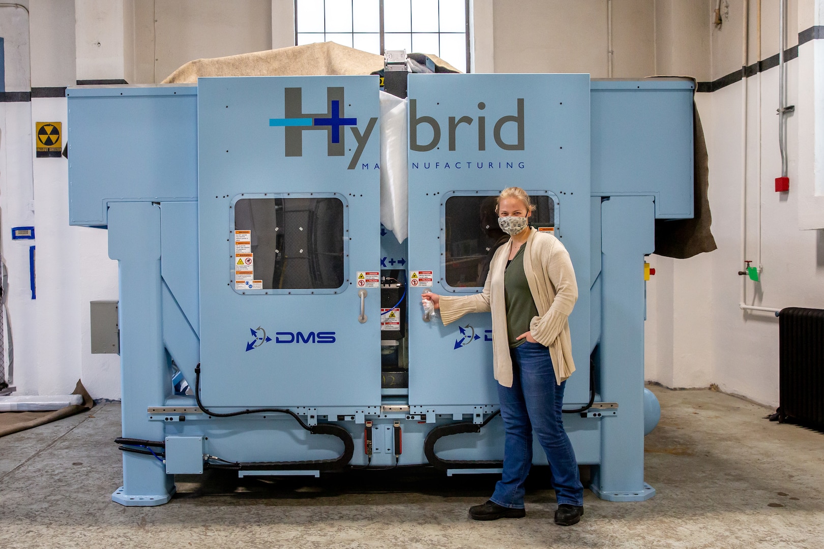 Norfolk Naval Shipyard (NNSY) Technology and Innovation (T&I) Additive Manufacturing (AM) Center of Excellence (CoE) Project Manager and AM Lead Jessica Roberts shares one of the 3-D metal printers that are being set up at the shipyard.