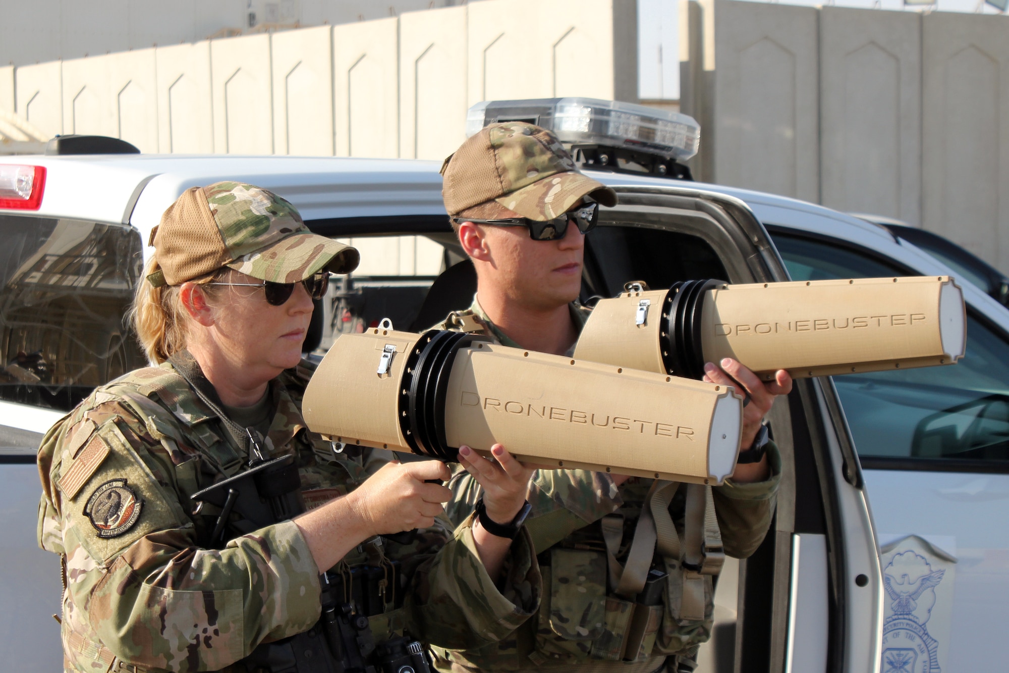 Tech. Sgt. Christina Cary and Tech. Sgt. Jacob Wirick each use a dronebuster to interrupt the signal to an Unmanned Aerial System, during an exercise at Al Dhafra Air Base, United Arab Emirates, Dec. 3, 2021. The 380th Expeditionary Security Forces Squadron at the base has responsibility for countering potential UAS threats.