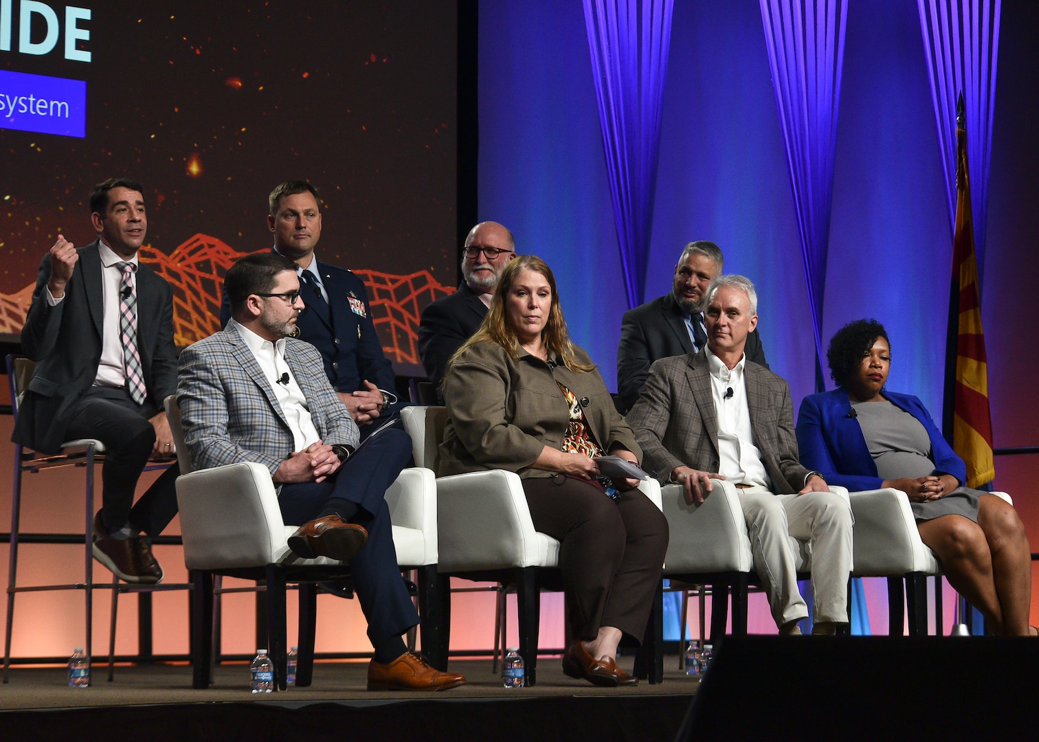 Image of person(s) on stage presenting to an audience.