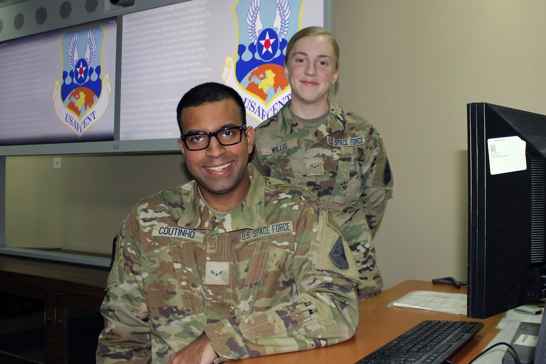 Spc3 Alex Coutinho and Spc3 Sophia Willis stand in the 380th Expeditionary Communications Squadron conference room at Al Dhafra Air Base, United Arab Emirates, Dec. 7, 2021. The two Guardians are among a small group of Space Force personnel working alongside the Airmen of the 380th Air Expeditionary Wing at Al Dhafra. (U.S. Air Force photo by Master Sgt. Dan Heaton)