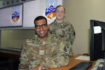 Spc3 Alex Coutinho and Spc3 Sophia Willis stand in the 380th Expeditionary Communications Squadron conference room at Al Dhafra Air Base, United Arab Emirates, Dec. 7, 2021. The two Guardians are among a small group of Space Force personnel working alongside the Airmen of the 380th Air Expeditionary Wing at Al Dhafra. (U.S. Air Force photo by Master Sgt. Dan Heaton)