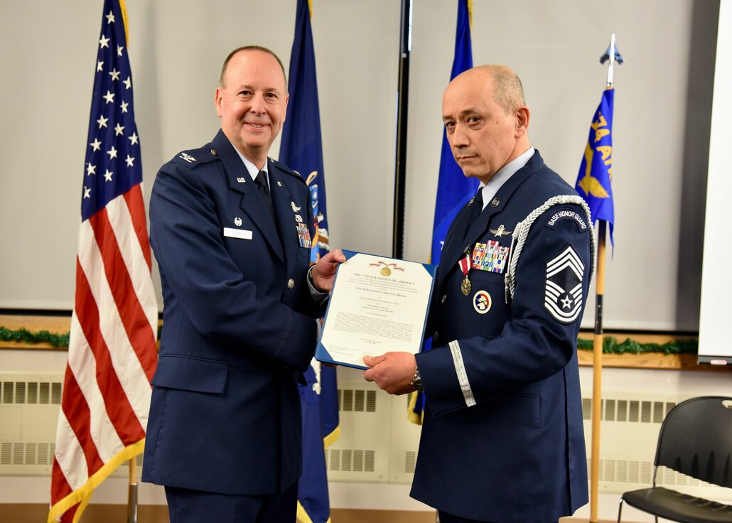 New York Air National Guard Chief Master Sgt. Bruce Fong (right) receives a Meritorious Service Medal from Col. Michael Adamitis, Commander of the 174th Mission Support Group,oln during a retirement ceremony held at Hancock Field Air National Guard Base, Syracuse, New York. (U.S. Air National Guard photo by Staff Sgt. Duane Morgan)
