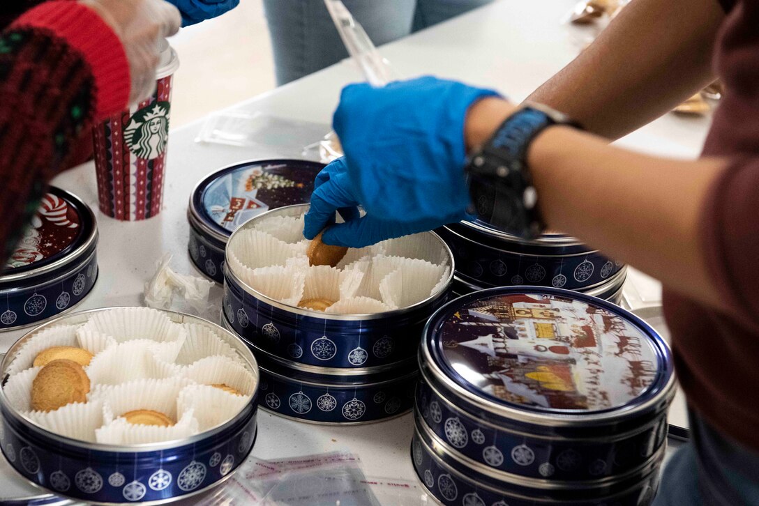 Members of the Andrews Spouses’ Club and Airmen volunteers from the 316th Comptroller Squadron separate shortbread cookies to put into mugs at Chapel 1, Joint Base Andrews, Md., Dec. 6, 2021