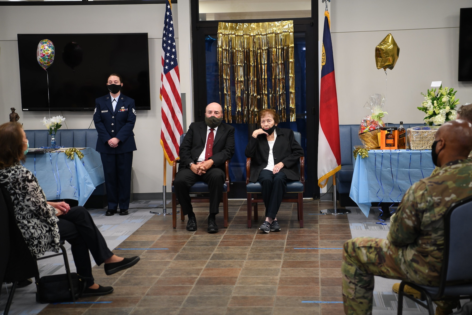 Mrs. Jere Firth (right) sits before an audience of retired and active military members for her retirement celebration after over 59 years of service as a civilian technician employee, at the NCANG Base, Charlotte Douglas International Airport, Nov. 19, 2021. Mrs. Firth has worked specifically for the North Carolina Air National Guard since 1972 and retires as one of the longest employed civilians in the Department of Defense.