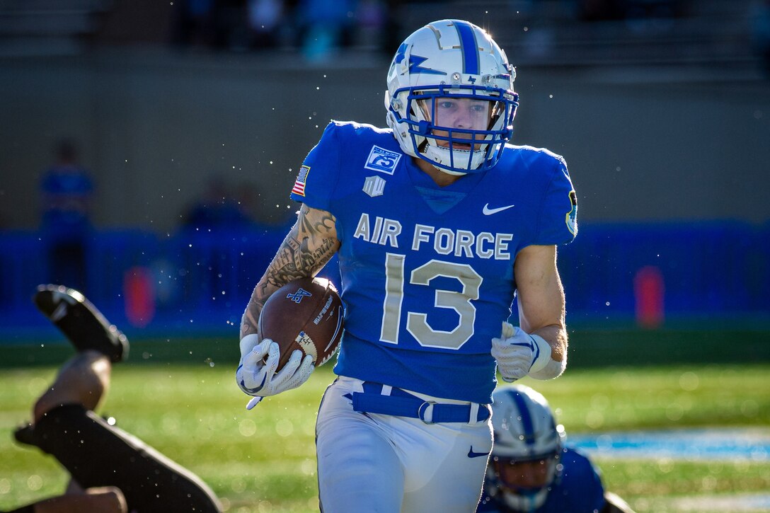 A football player carries the ball.