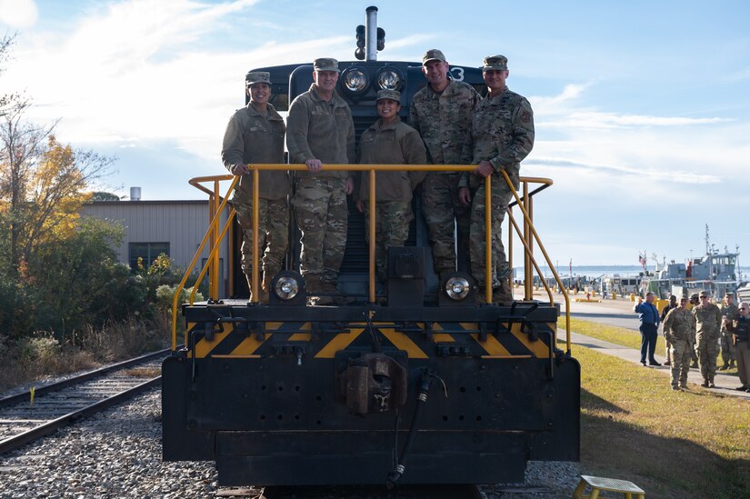 From left, U.S. Air Force Chief Master Sgt. Sonia T. Lee, 15th Air Force command chief, Maj. Gen. Michael G. Koscheski, 15th AF commander, Chief Master Sgt. Maribeth Ferrer, 633d Air Base Wing command chief, Col. Gregory Beaulieu, 633d ABW command, and U.S. Army Colonel Chesley Thigpen, 733d Mission Support Group commander, pose for a group photo on a 7th Transportation Battalion locomotive at Joint Base Langley-Eustis, Virginia, Dec. 1, 2021.