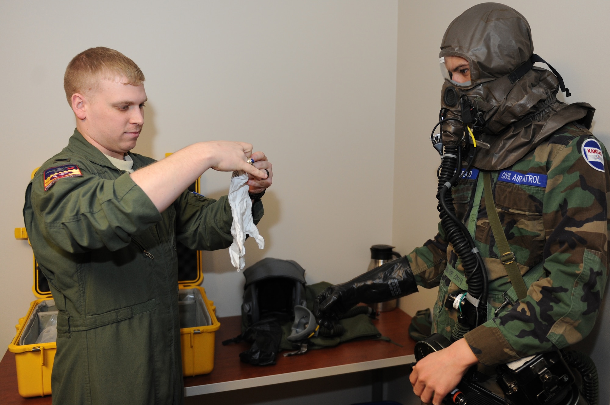 1st Lt. Ryan Cobb, 384th Air Refueling Squadron navigator, helps a Civil Air Patrol cadet suit up in Mission Oriented Protective Posture gear March 3, 2014, at McConnell Air Force Base, Kan. CAP cadets visited the KC-135 Stratotanker simulator and refueled different planes using the KC-135 Boom Operator Weapon System Trainer. (U.S. Air Force photo/Airman 1st Class David Bernal Del Agua)