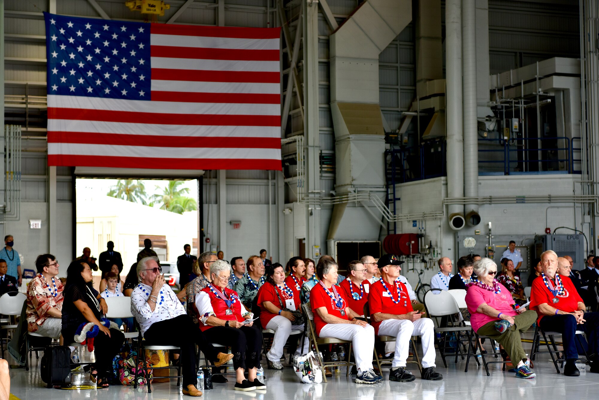 Attendees watch the December 7th Remembrance Ceremony inside Hangar 19 at Joint Base Pearl Harbor-Hickam, Hawaii, Dec. 7, 2021. The event brought together Airmen, Guardians, survivor family members, and more to honor those who gave their lives 80 years ago. (U.S. Air Force photo by 1st Lt. Benjamin Aronson)