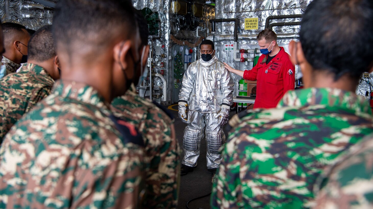 Electronics Technician 1st Class JT Bryant, from San Marino, California, center left, and Hull Technician 1st Class Andrew Vanwagner, from Lagrangeville, New York, center right, conduct flight deck firefighting training with members of the Timor-Leste Defense Force during Cooperation Afloat Readiness and Training (CARAT) from the hangar bay aboard Independence-variant littoral combat ship USS Charleston (LCS 18). In its 27th year, the CARAT series is comprised of multinational exercises, designed to enhance U.S. and partnered navies’ abilities to operate together in response to traditional and non-traditional maritime security challenges in the Indo-Pacific region. Charleston, part of Destroyer Squadron (DESRON) 7, is on a rotational deployment in the U.S. 7th Fleet area of operation to enhance interoperability with partners and serve as a ready-response force in support of a free and open Indo-Pacific region.