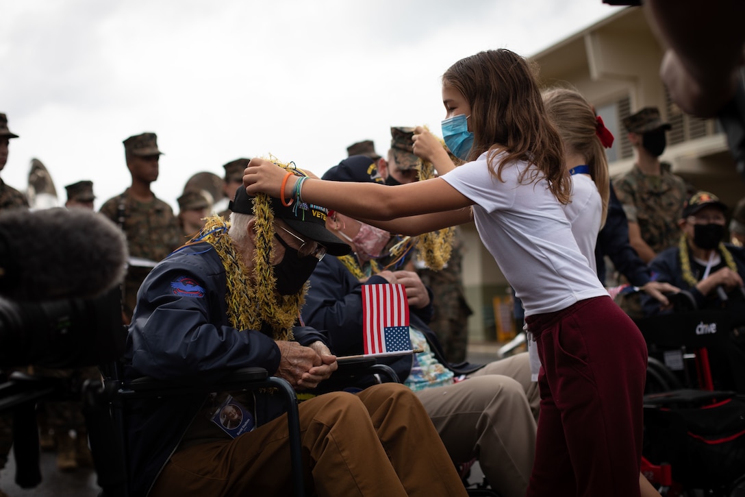 Harold Stephens, a World War II veteran, receives a lei from a student during a visit to Mokapu Elementary School, Marine Corps Base Hawaii, Dec. 6, 2021. The visit was coordinated by the Best Defense Foundation in order to commemorate the 80th anniversary of the attack on Pearl Harbor. Stephens was drafted into the U.S. Army in 1943, arrived in France four days after D-Day, and went on to fight in the Battle of the Bulge as a corporal technician in communications, eventually being discharged from service on November 6, 1945. (U.S. Marine Corps photo by Cpl. Brandon Aultman)