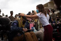 Harold Stephens, a World War II veteran, receives a lei from a student during a visit to Mokapu Elementary School, Marine Corps Base Hawaii, Dec. 6, 2021. The visit was coordinated by the Best Defense Foundation in order to commemorate the 80th anniversary of the attack on Pearl Harbor. Stephens was drafted into the U.S. Army in 1943, arrived in France four days after D-Day, and went on to fight in the Battle of the Bulge as a corporal technician in communications, eventually being discharged from service on November 6, 1945. (U.S. Marine Corps photo by Cpl. Brandon Aultman)