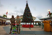 U.S. Marine Corps Col. Speros Koumparakis, right, commanding officer, Marine Corps Base Hawaii, and Sgt. Maj. Lester Williams, left, sergeant major, MCBH, light the tree during the tree lighting ceremony at the Mokapu Mall on Marine Corps Base Hawaii, Nov. 23, 2021. The annual tree lighting ceremony celebrates the start of the holiday season for MCBH. (U.S. Marine Corps photo by Cpl. Samantha Sanchez)
