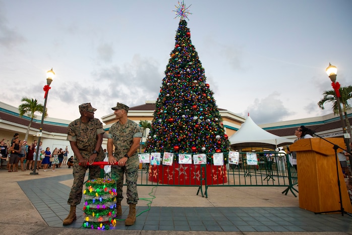 U.S. Marine Corps Col. Speros Koumparakis, right, commanding officer, Marine Corps Base Hawaii, and Sgt. Maj. Lester Williams, left, sergeant major, MCBH, light the tree during the tree lighting ceremony at the Mokapu Mall on Marine Corps Base Hawaii, Nov. 23, 2021. The annual tree lighting ceremony celebrates the start of the holiday season for MCBH. (U.S. Marine Corps photo by Cpl. Samantha Sanchez)